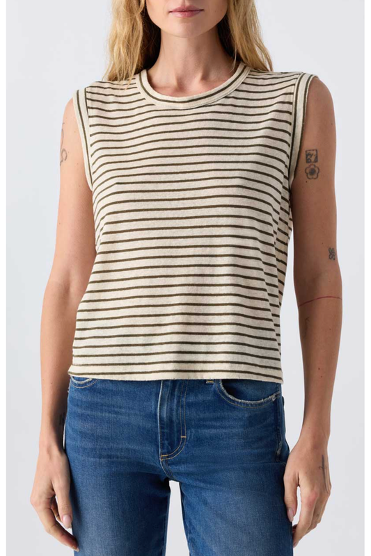 Woman wearing a striped sleeveless top and blue jeans against a plain background