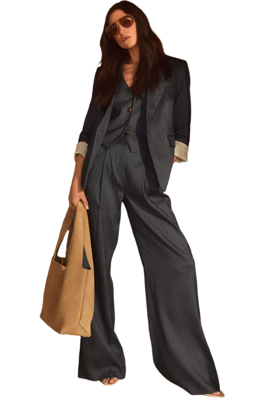 Person wearing a gray suit holding a beige bag against a wooden wall.