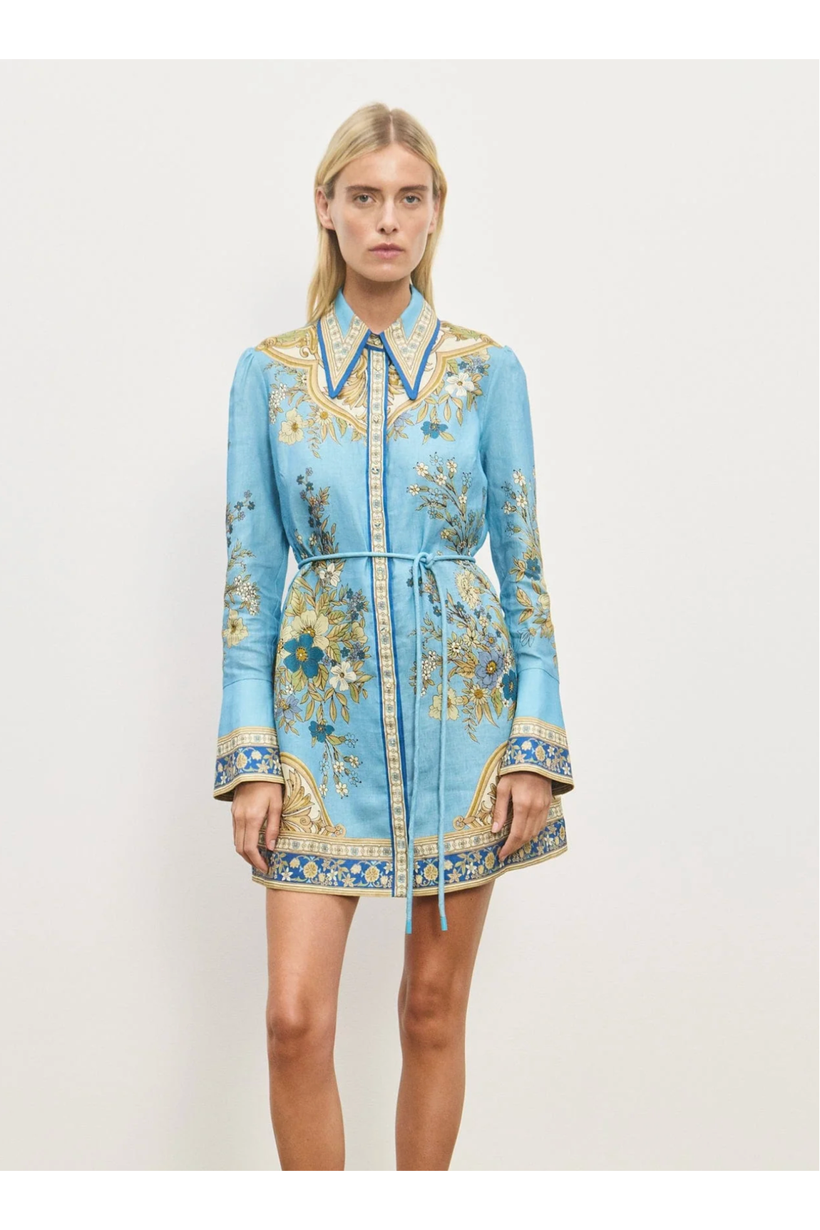 Woman wearing a blue floral dress with a white background