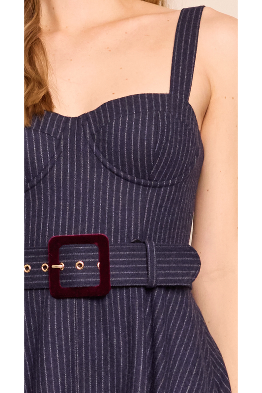 Navy pinstripe dress with a belt and gold buckle on a person.