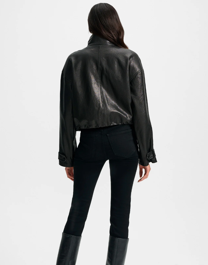 Person wearing a black leather jacket and pants on a white background