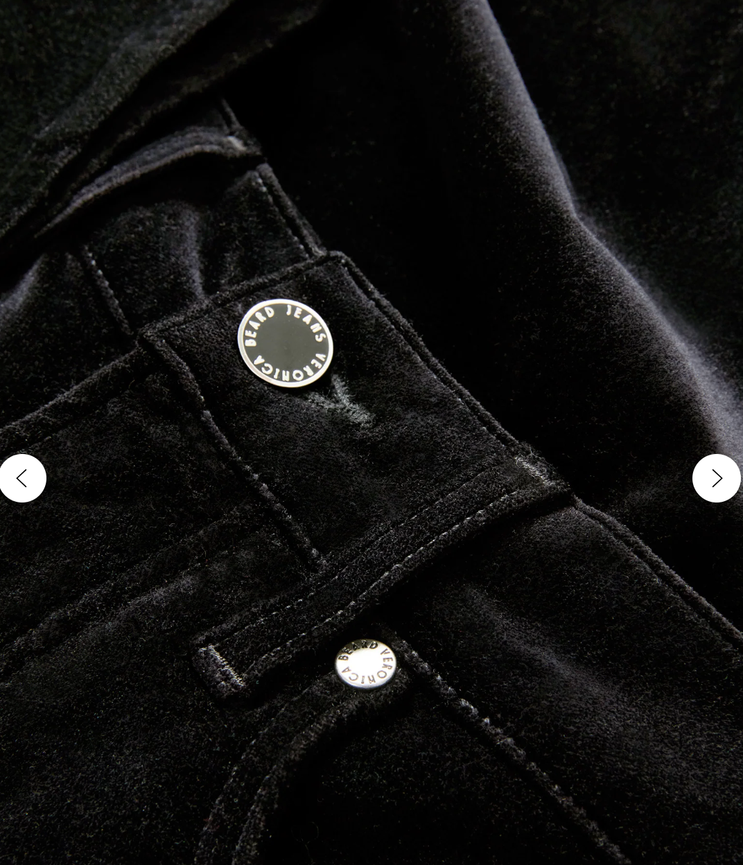 Woman wearing a sleeveless patterned top and black flared pants on a plain background