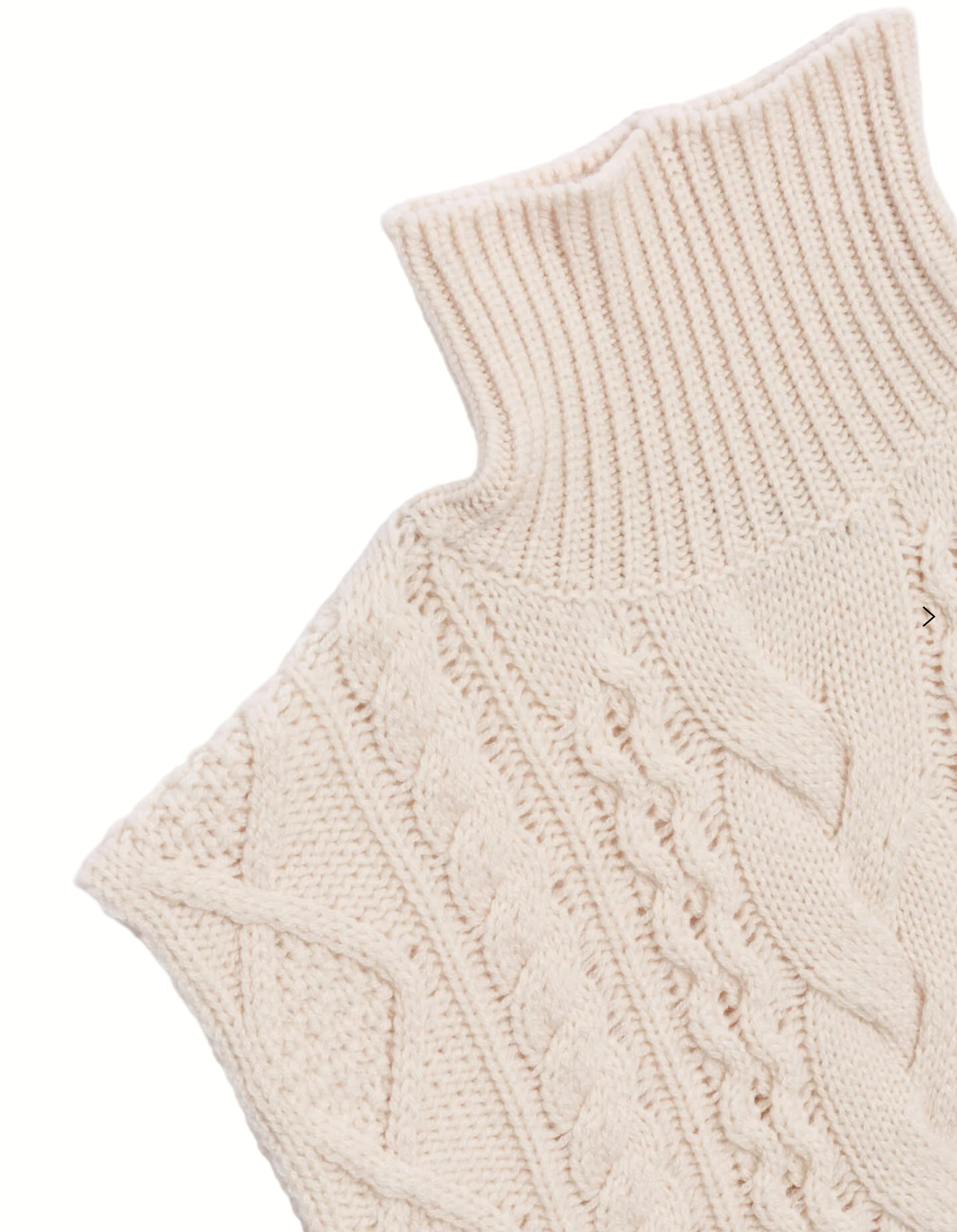 Close-up of a cream-colored knitted sleeveless sweater with cable knit pattern on a light gray background.