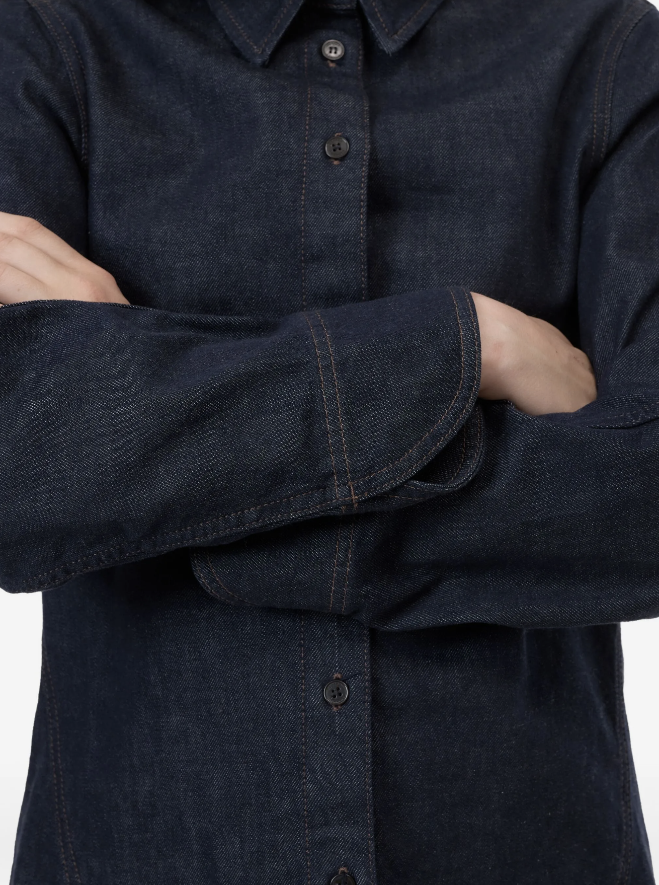 Dark denim shirt with button details on a plain background