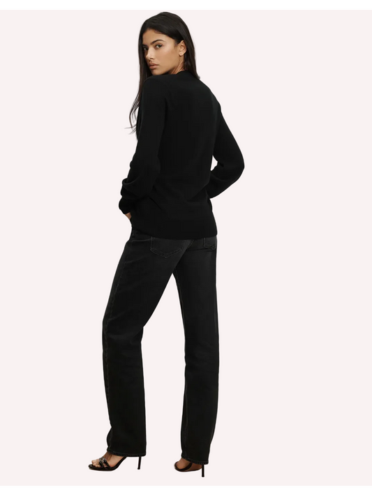 Woman wearing a black outfit standing against a white background