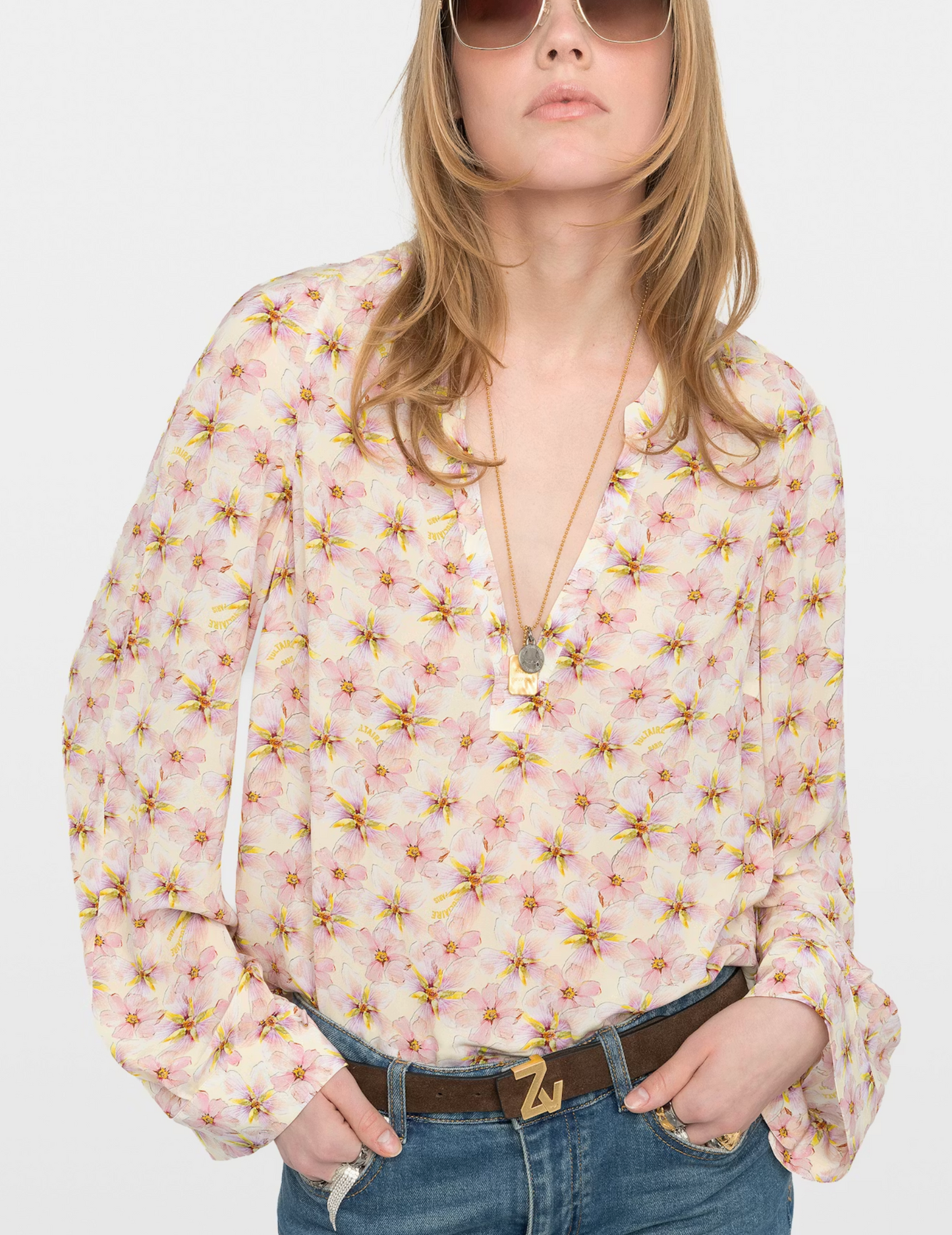 Woman wearing a floral blouse and sunglasses on a white background