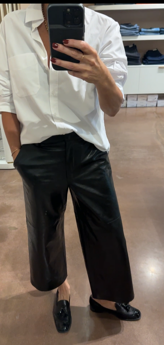Person wearing a white shirt and black pants in a store setting