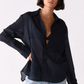 Woman wearing a black shirt and light blue jeans on a white background