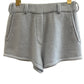Blue cashmere shorts with pockets on a hanger against a white background