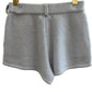 Blue cashmere shorts on a hanger against a white background