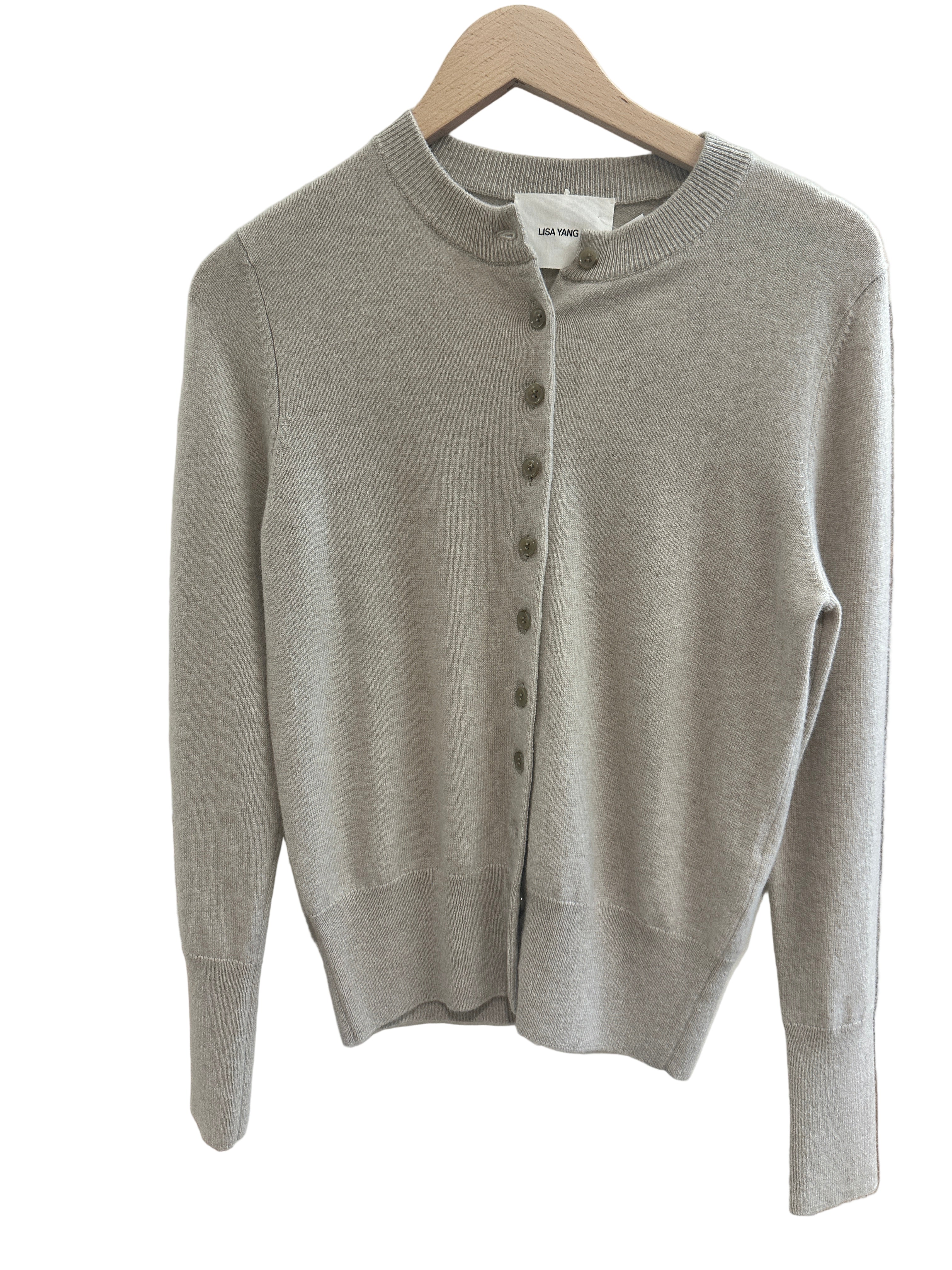 Sand Beige sweater on a white surface with a blurred background