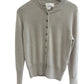Sand Beige sweater on a white surface with a blurred background