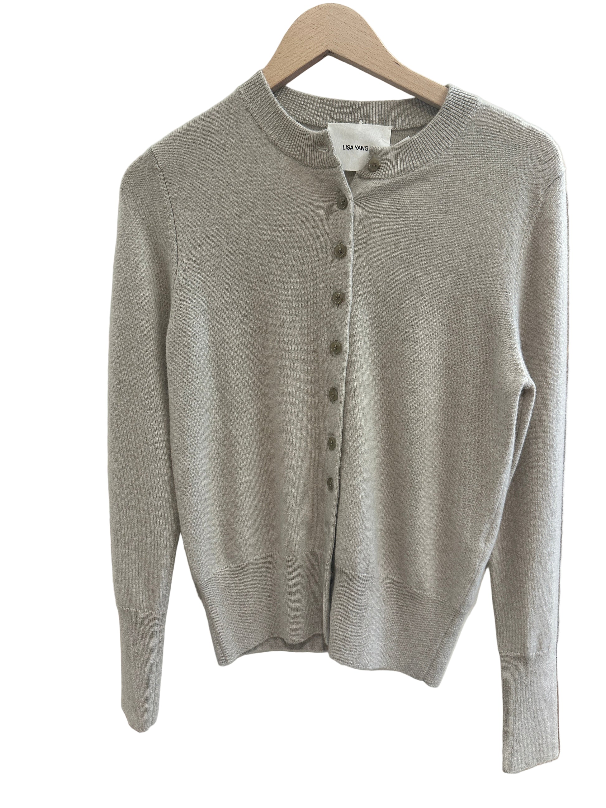 Sand Beige sweater on a white surface with a blurred background
