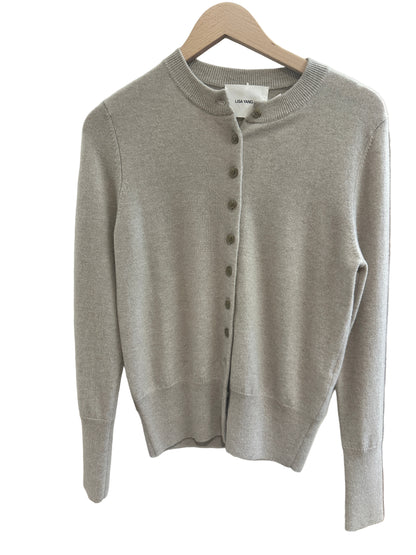 Sand Beige sweater on a white surface with a blurred background