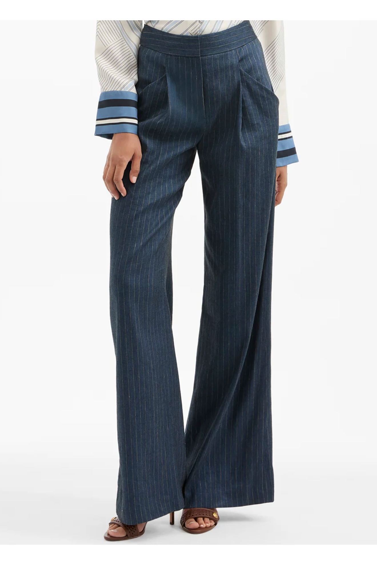 Navy pinstripe pants worn with a white shirt on a white background