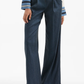 Navy pinstripe pants worn with a white shirt on a white background