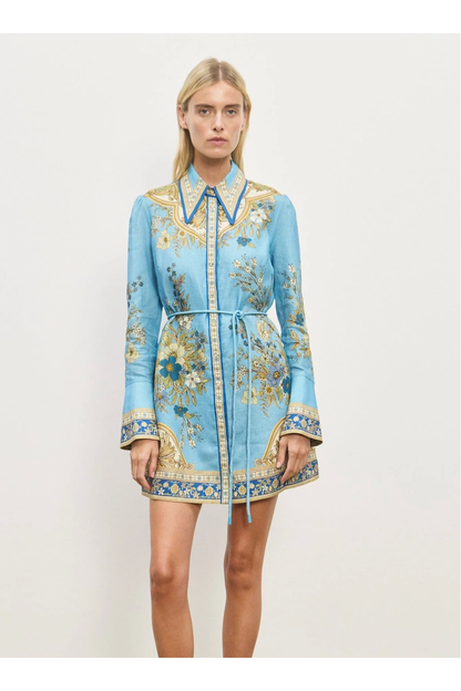 Woman wearing a blue floral dress with a white background