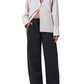 Person wearing a light-colored jacket and black pants on a white background