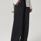 Person wearing black wide-leg pants with a light gray top on a white background