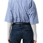 Person wearing a blue striped shirt and dark jeans from behind on a plain background