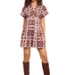 Woman wearing a patterned dress with brown knee-high boots on a beige background