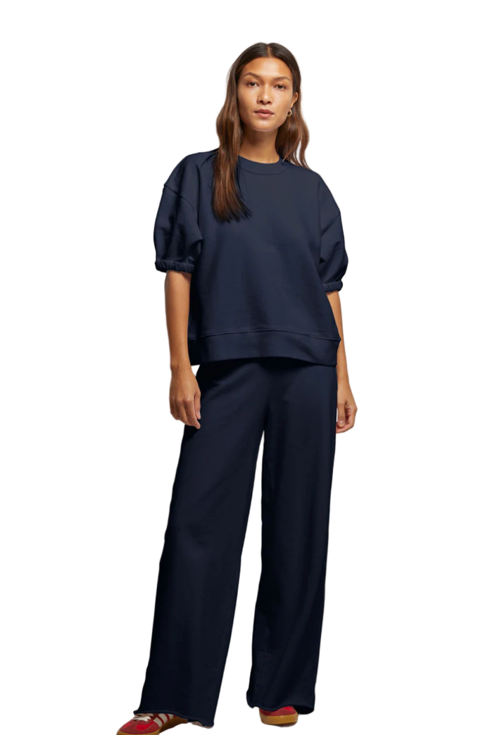 Woman wearing a navy blue outfit against a white background