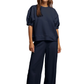 Woman wearing a navy blue outfit against a white background