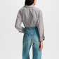Person wearing a striped shirt and blue jeans on a white background