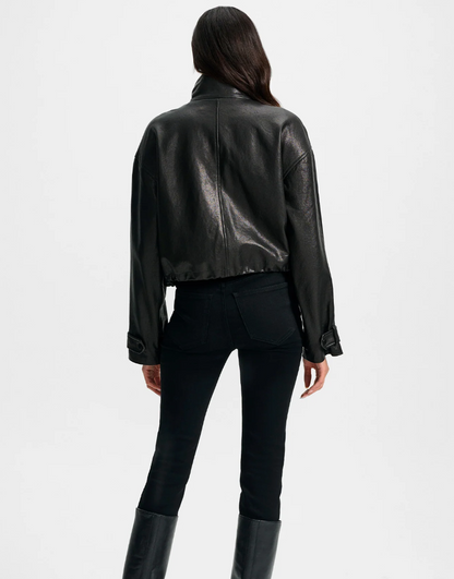 Person wearing a black leather jacket and pants on a white background