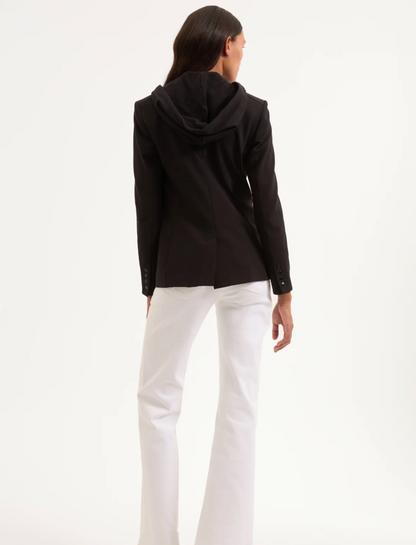 Person wearing a black jacket and white pants on a white background