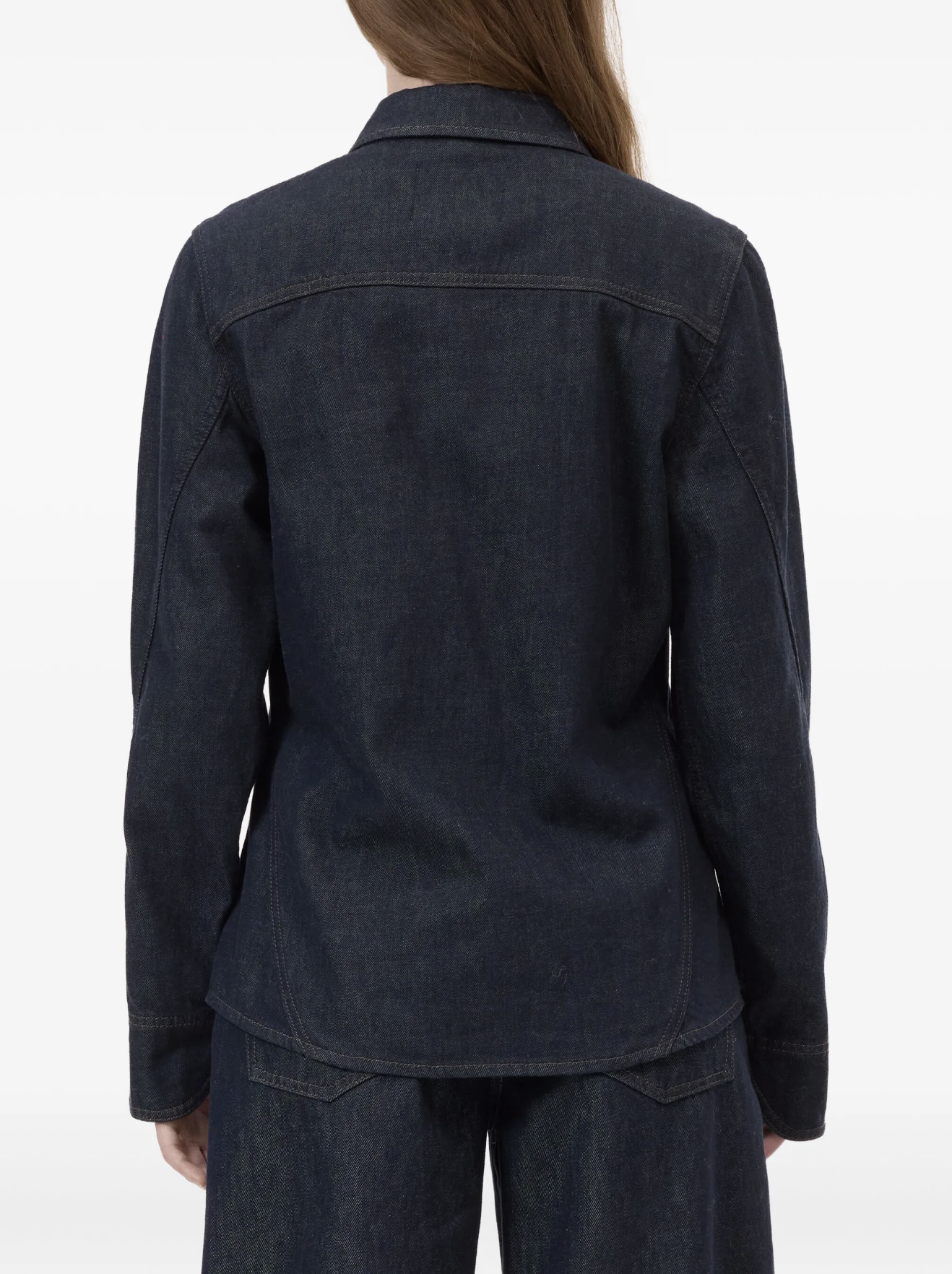 Dark denim jacket worn by a person on a white background