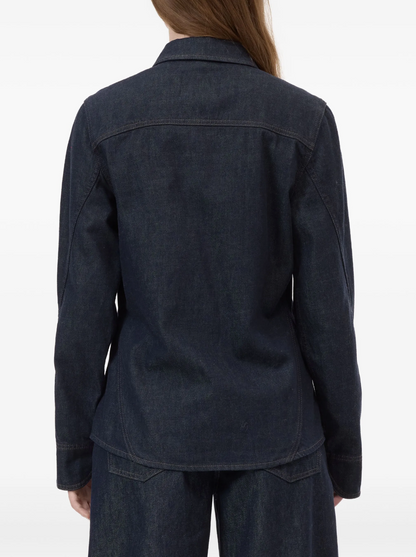 Dark denim jacket worn by a person on a white background