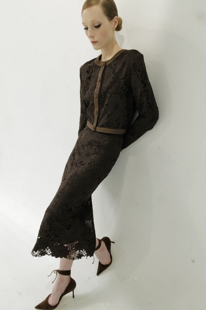 Woman wearing a black lace outfit against a white background