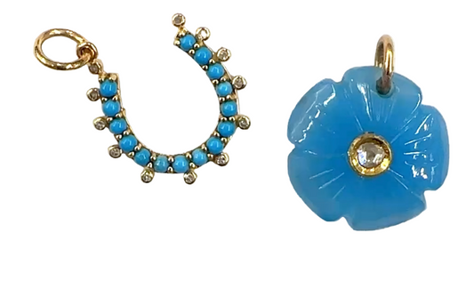 Two blue pendants, one shaped like a horseshoe and the other like a flower, on a white background.