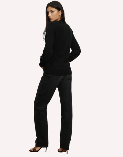 Woman wearing a black outfit standing against a white background