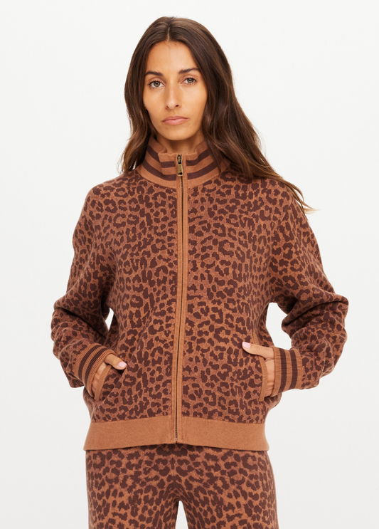 Woman wearing a brown leopard print tracksuit on a white background