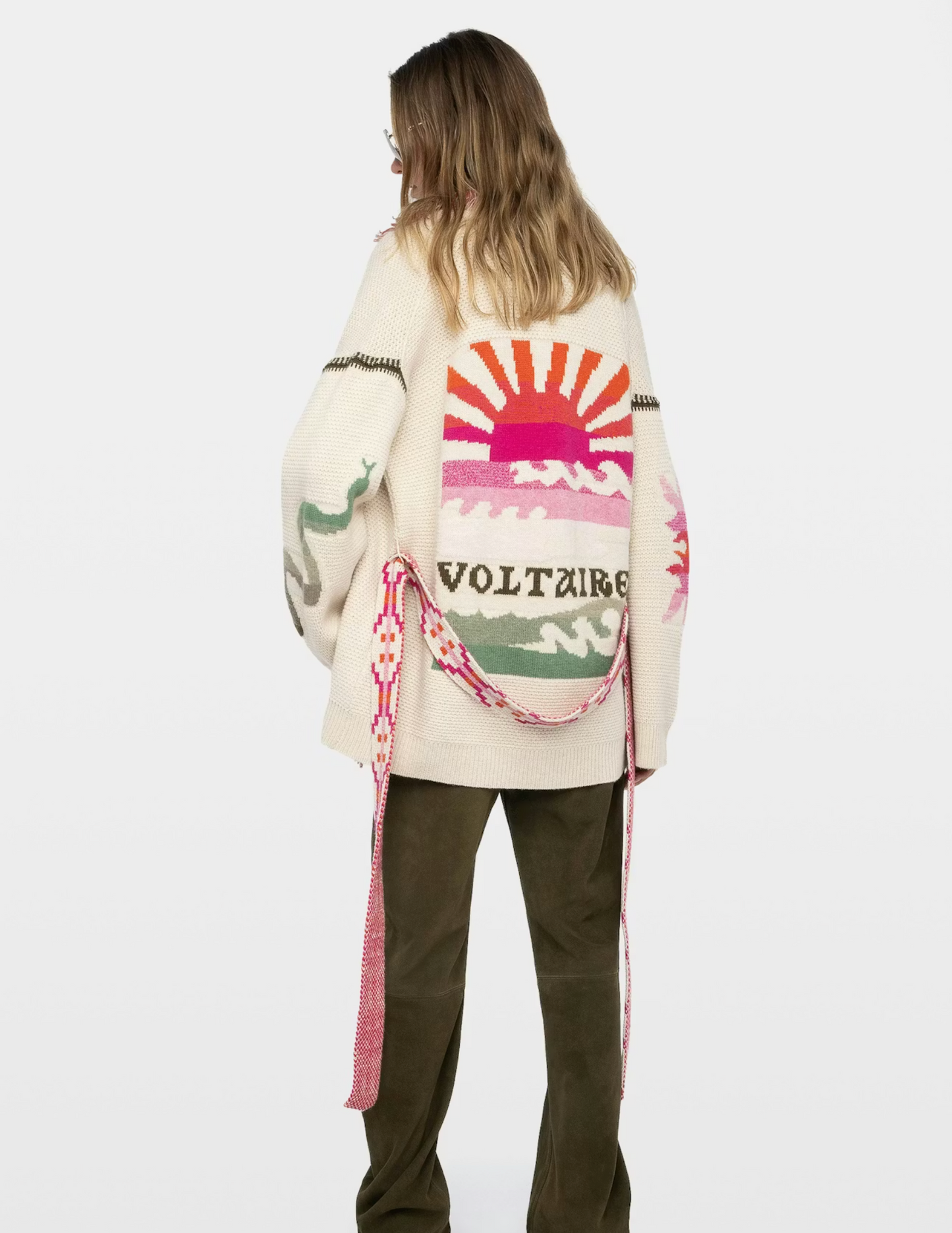 Person wearing a colorful cardigan with a logo on the back against a white background