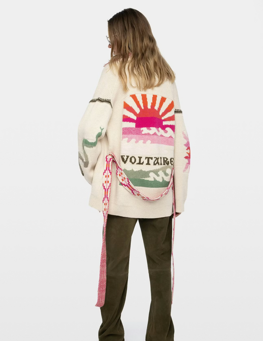 Person wearing a colorful cardigan with a logo on the back against a white background