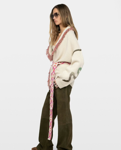 Woman wearing a patterned sweater and green pants on a white background