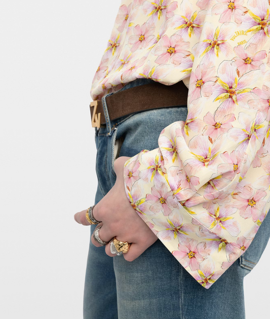 Person wearing a floral jacket with a plain background