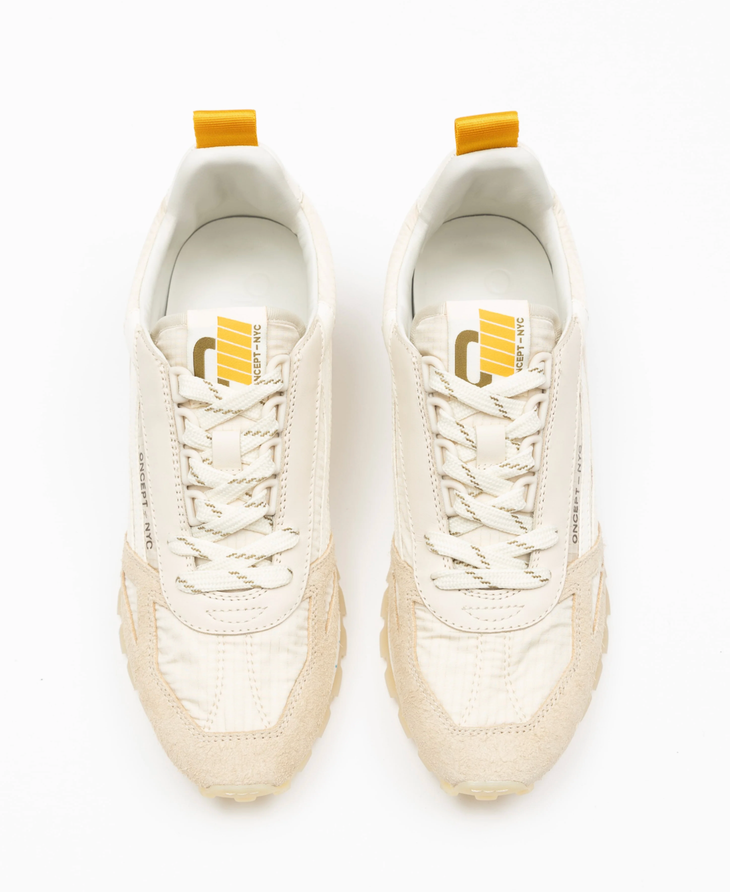 Pair of white sneakers with yellow accents on a white background