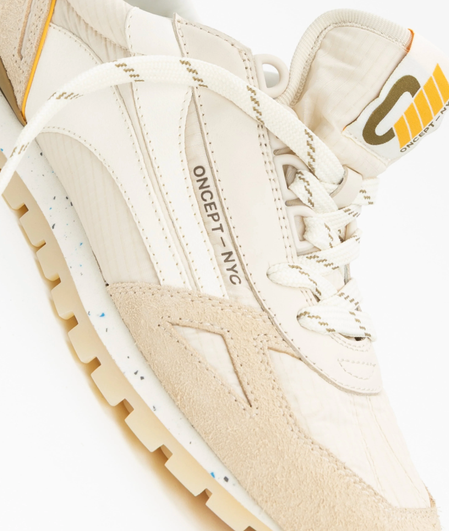 Close-up of a beige sneaker with 'ONCEPT NYC' branding on a white background