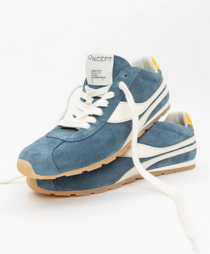 Blue sneakers with white laces and sole on a white background