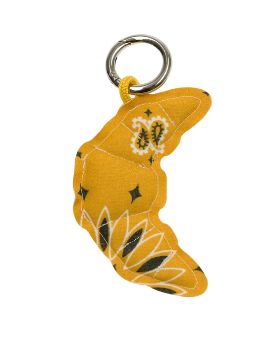 Yellow keychain with floral patterns on a light gray background