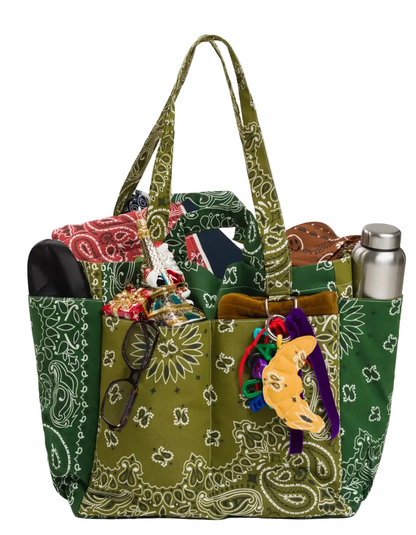 Green patterned handbag with accessories on a white background