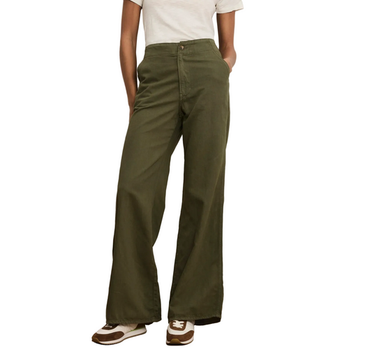 Person wearing olive green pants with a plain background