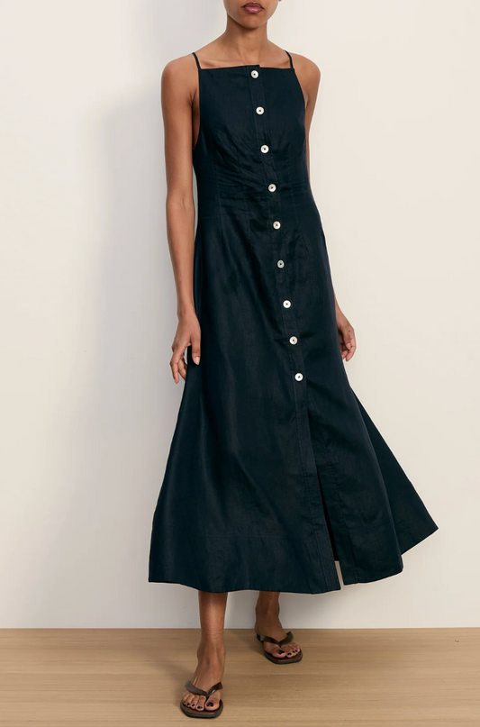 Black dress with button details worn by a person on a plain background