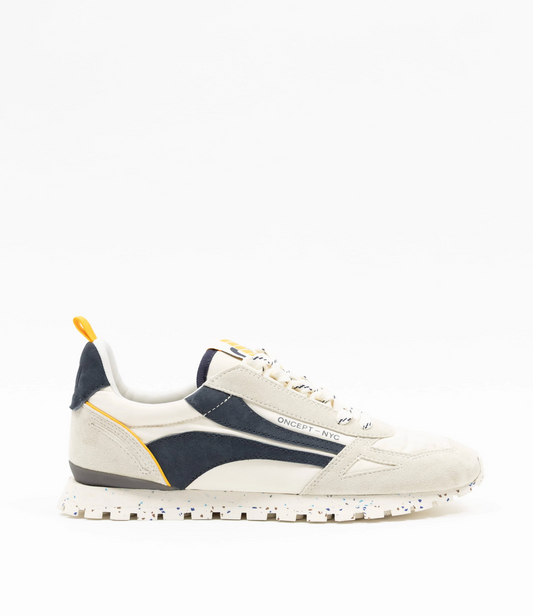 White and navy sneaker with yellow accents on a white background