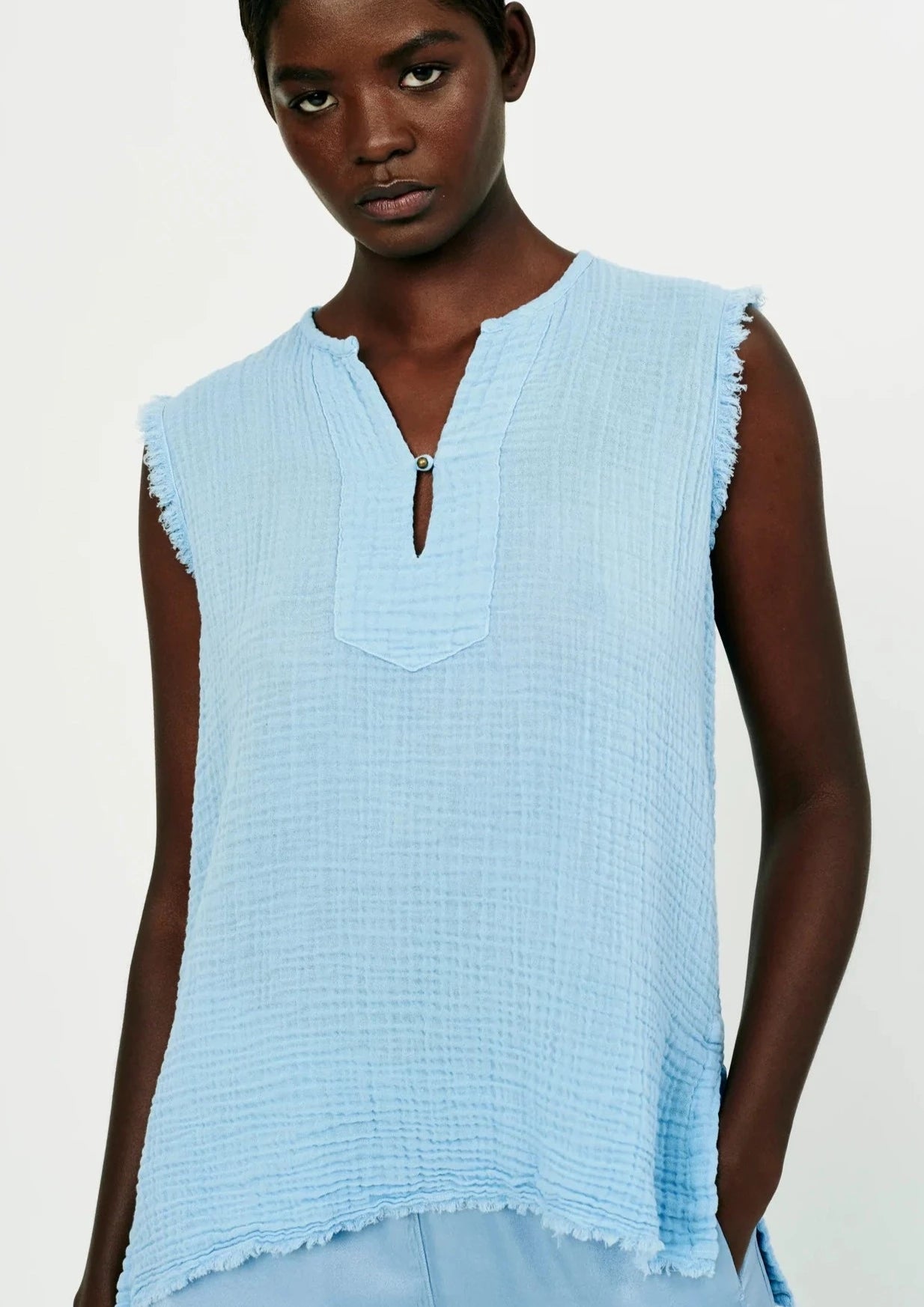 This soft gauze top has frayed armholes and bottom hems.   100% cotton.  Runs true to size.